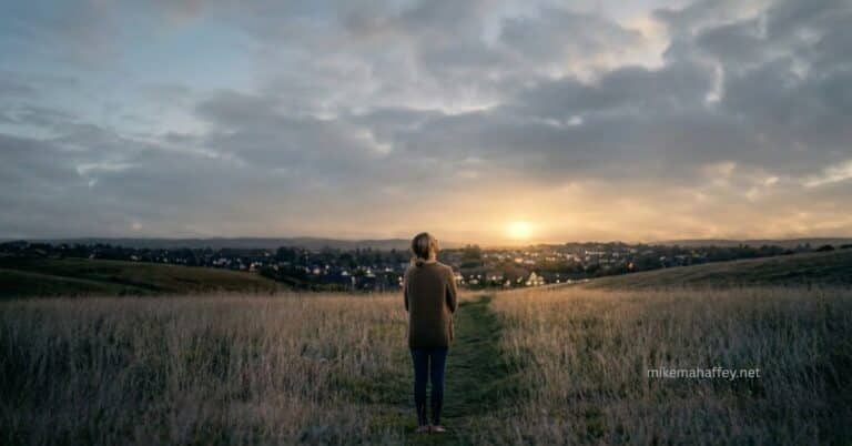 A woman stands alone in a dim field on a narrow path, facing a distant golden light on the horizon, reflecting the search for true understanding of what it means to fear God.