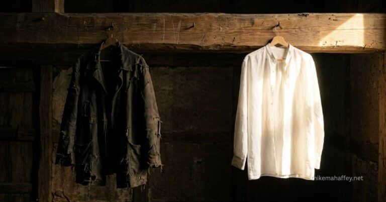 A dark tattered garment hangs in shadow beside a clean white robe catching warm light on a rough wooden beam, illustrating the great exchange of 2 Corinthians 5:21 where Christ took our sin and gave us His righteousness.