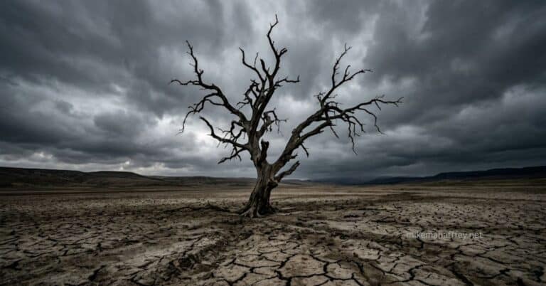 A dead, bare tree stands alone on dry cracked earth beneath a dark stormy sky, visually representing total depravity — the complete reach of sin into every part of human nature.