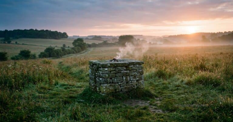 Ancient stone altar at dawn with morning light and rising smoke, representing the substitutionary sacrifice that answers why God requires blood.