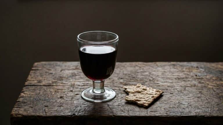 A communion cup and broken bread on a wooden surface, representing the declaration of the new covenant in the Lord's Supper and the blood of Jesus.
